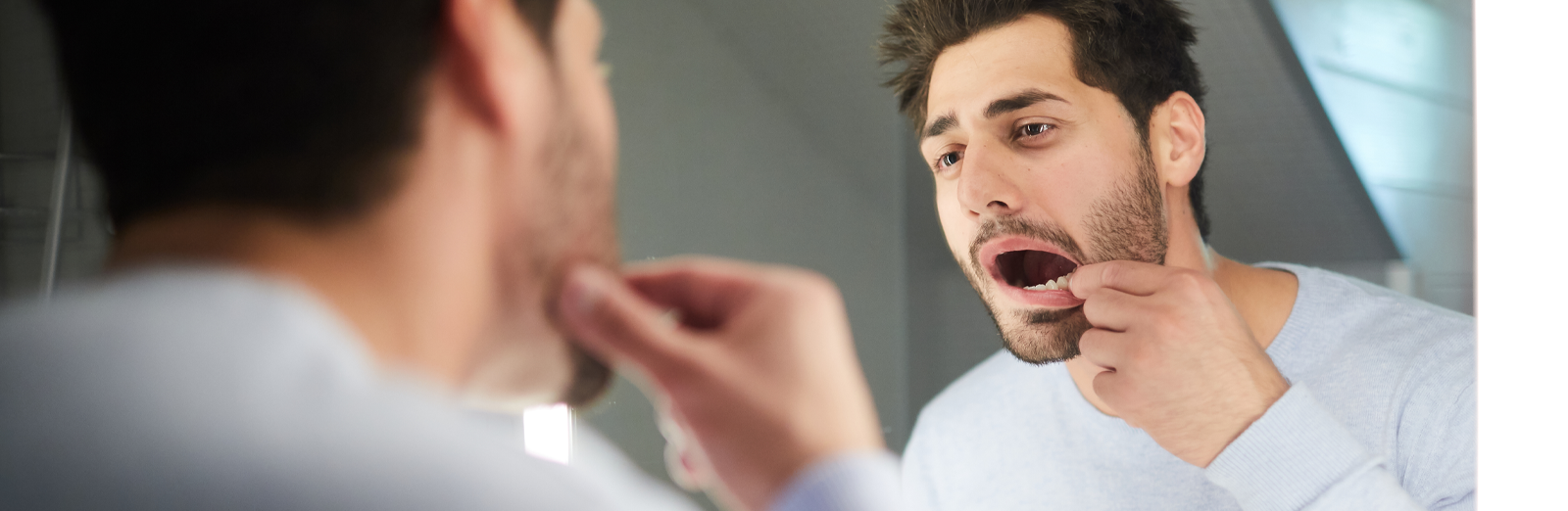 man-looking-at-teeth-1600x522.png