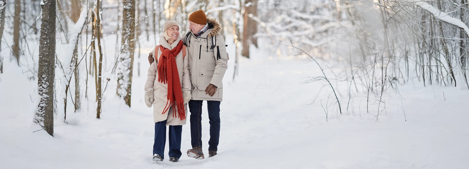 couple-walking-on-snowy-path-1600x578.webp