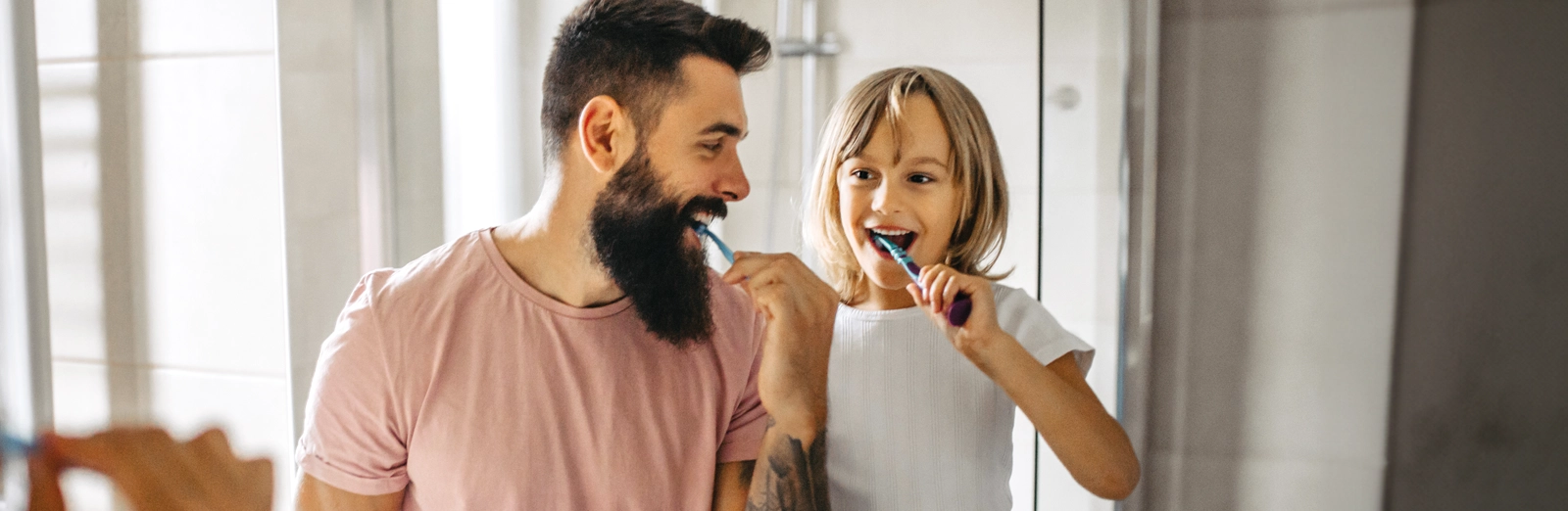 father-and-daughter-brushing-their-teeth-1600x522.webp