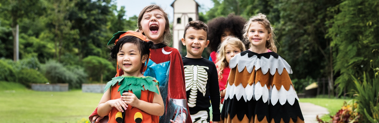 kids-smiling-in-halloween-costumes-1600x522.webp