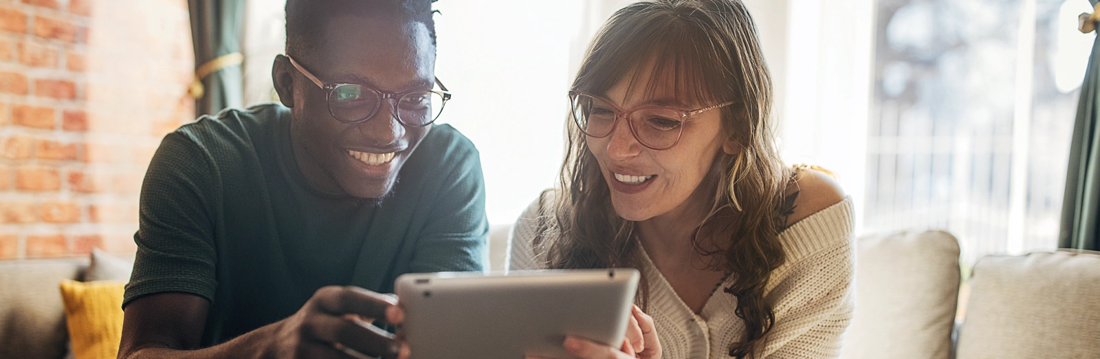 couple-looking-at-tablet-1600x522.webp