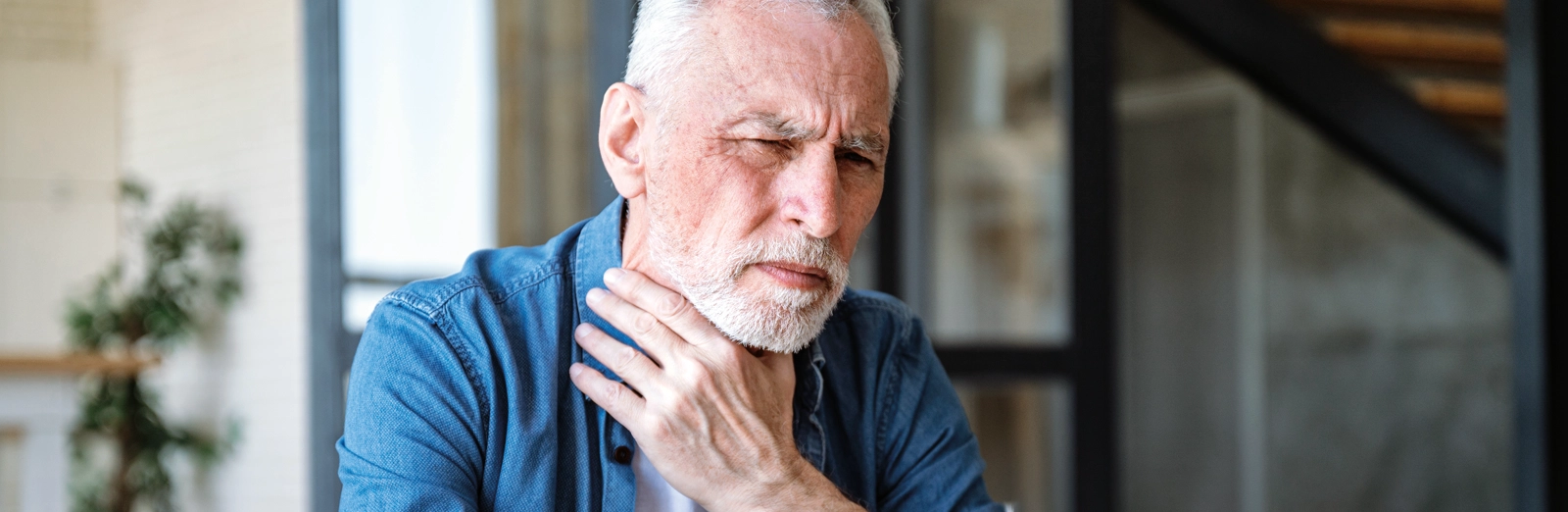 older-man-holding-his-throat-1600x522.webp